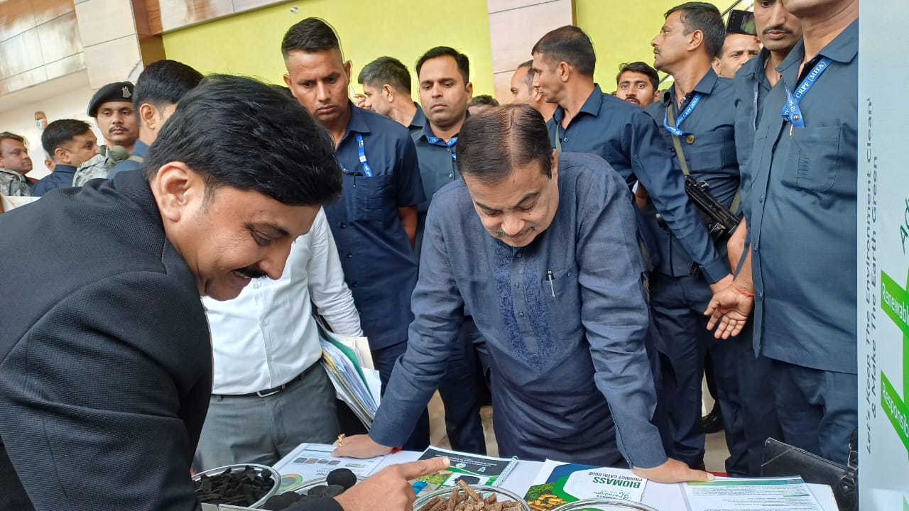 Officials inspecting biomass samples at an exhibition booth